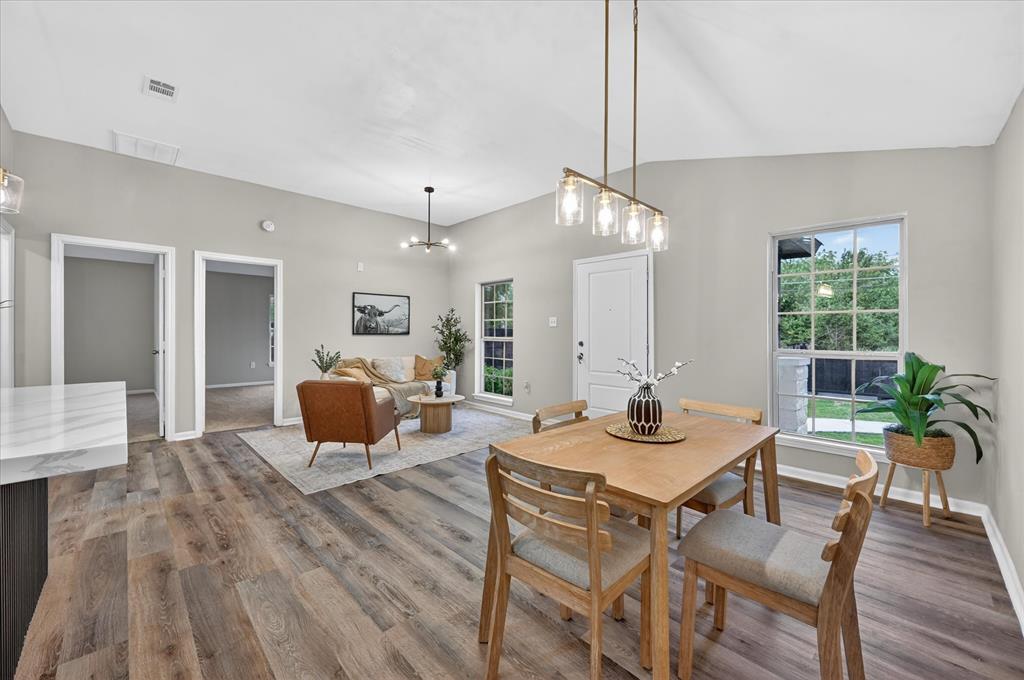 538 Pemberton Hill Road Dallas, TX 75217 - Photo 5 of 31 Open-concept living space featuring wood-finish flooring, vaulted ceilings, and light gray wall paint