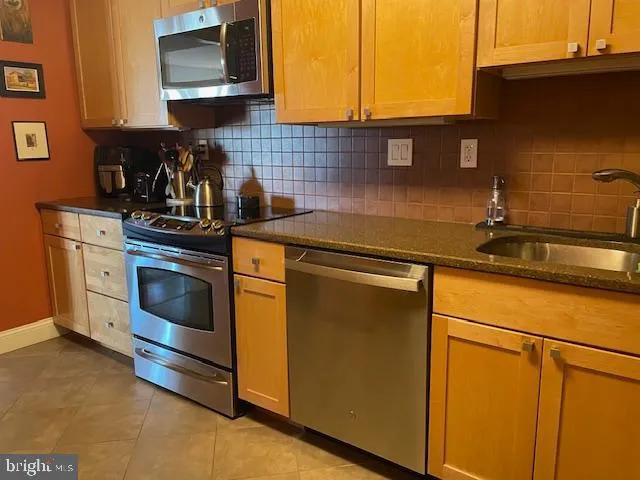 a kitchen with stainless steel appliances a refrigerator stove and microwave