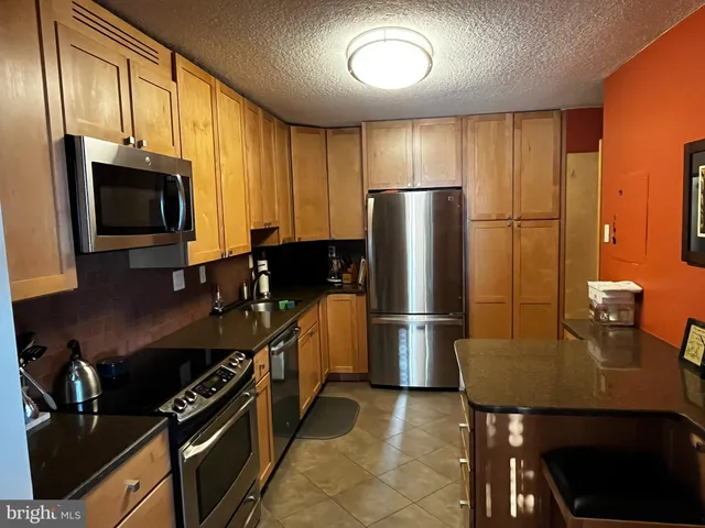 a kitchen with stainless steel appliances a refrigerator a stove a sink and a microwave