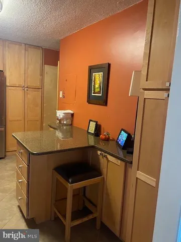 a kitchen with stainless steel appliances granite countertop wooden cabinets a stove a sink and a refrigerator