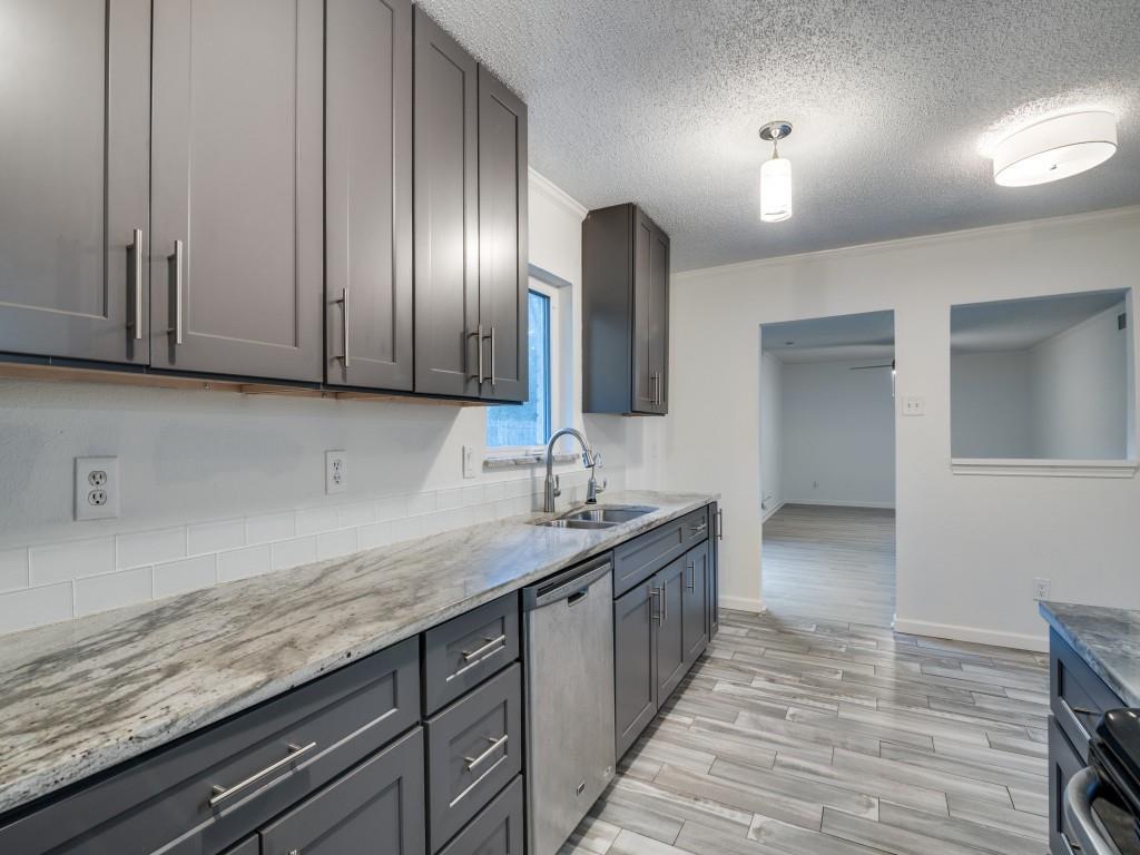 3425 Tarkio Road Plano, TX 75074 - Photo 11 of 25 a kitchen with granite countertop a sink and cabinets