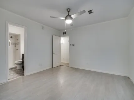 an empty room with fan and entrance