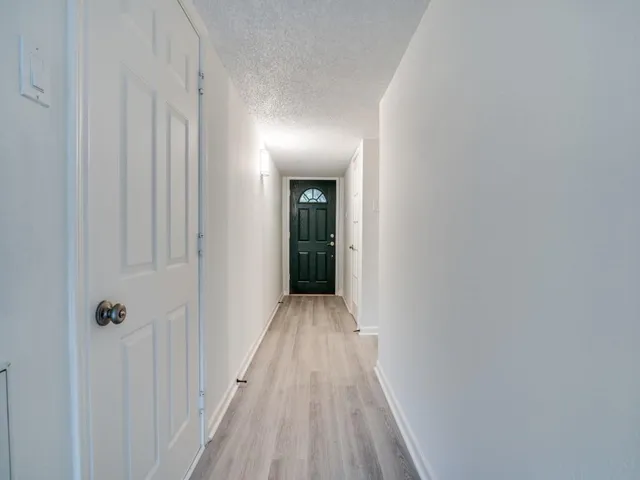a view of a hallway with wooden floor