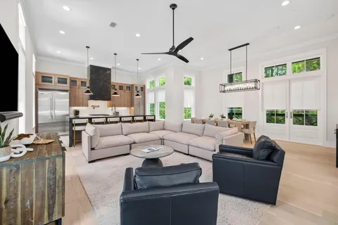 a living room with furniture kitchen view and a large window