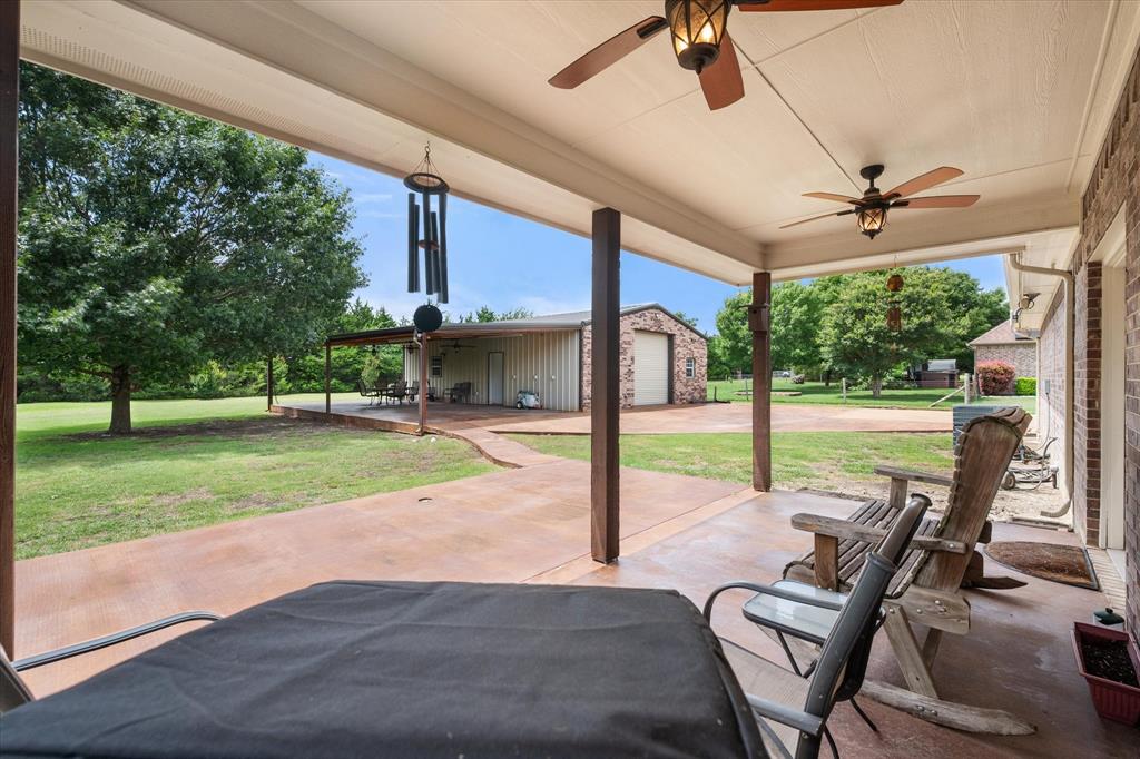 413 Rugged Drive Red Oak, TX 75154 - Photo 29 of 39 View from the large back patio off the house looking to the second covered patio attached to the shop - again showing the private back