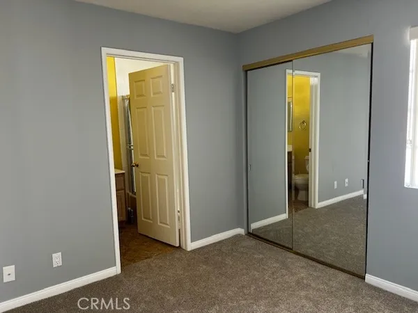 an empty room with a door and a bathroom