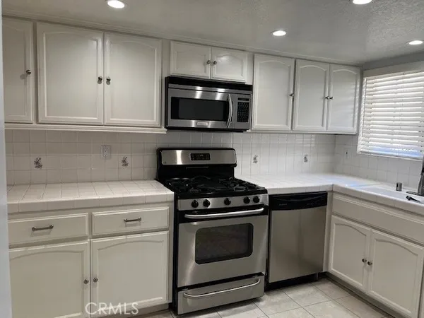 a kitchen with white cabinets and stainless steel appliances