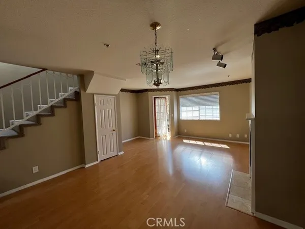 a view of a livingroom with wooden floor and stairs