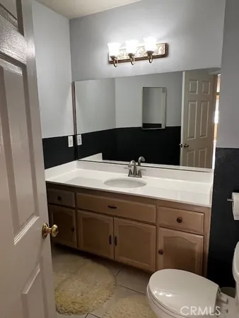 a bathroom with a toilet a sink and mirror