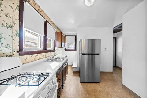 a kitchen with refrigerator a sink and a stove