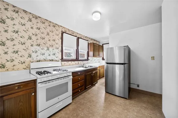 a kitchen with a stove top oven and refrigerator