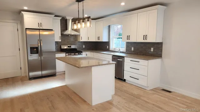 a kitchen with stainless steel appliances a refrigerator sink and microwave