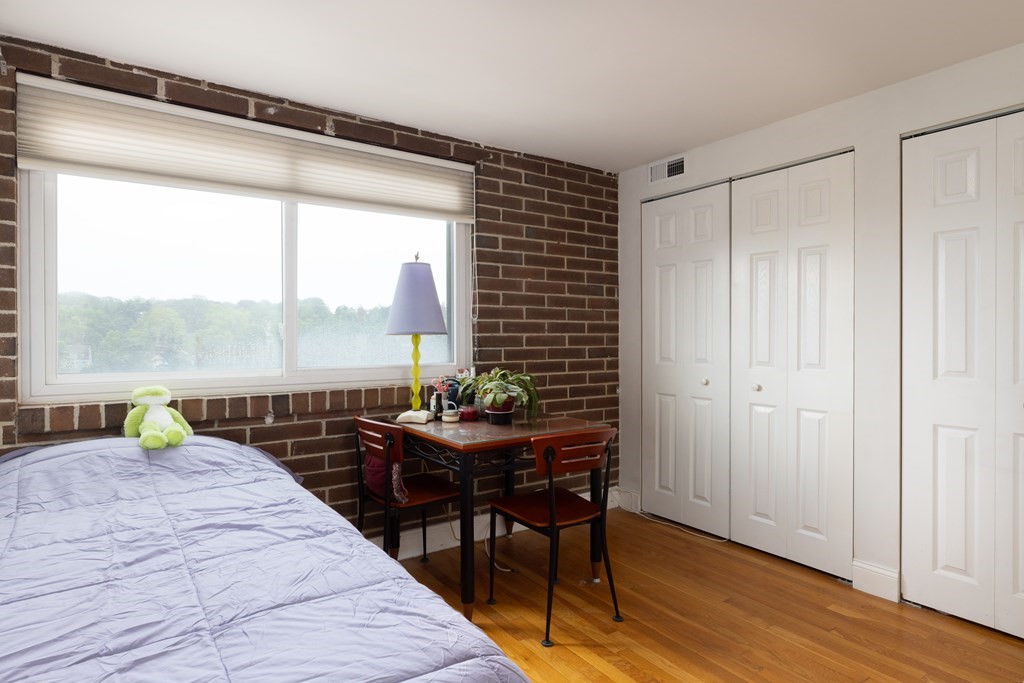 1856 Beacon Street, Unit PHA Brookline, MA 02445 - Photo 7 of 12 a bedroom with a bed and a table