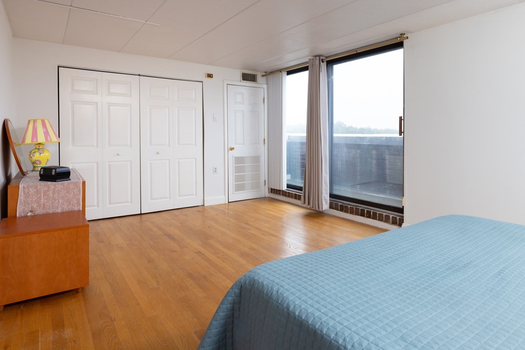 1856 Beacon Street, Unit PHA Brookline, MA 02445 - Photo 9 of 12 a bedroom with a bed and a chandelier