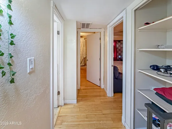 a view of a hallway with wooden floor and closet