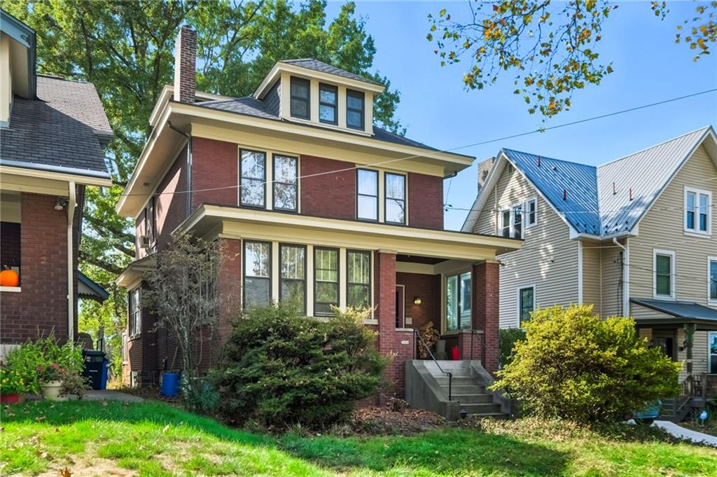front view of a brick house with a yard
