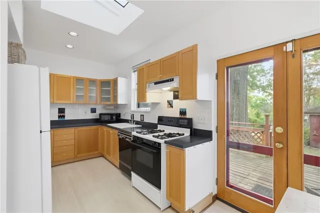 a kitchen with stainless steel appliances granite countertop a stove a sink and a refrigerator