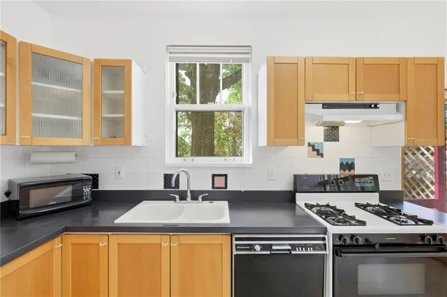 a kitchen with a stove a sink and a granite counter tops