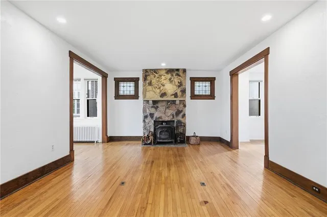 a view of a livingroom with wooden floor and a fireplace