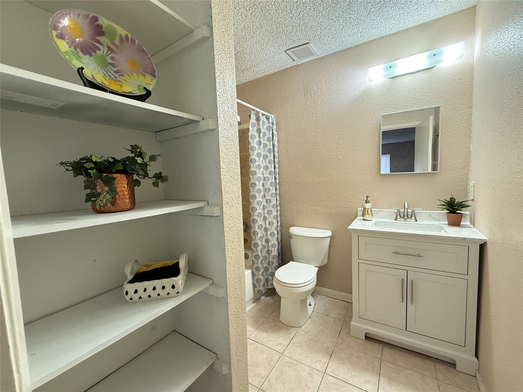 3219 Forestbrook Drive Spring, TX 77373 - Photo 10 of 16 Primary bathroom features tiled flooring, a modern vanity marble top and a shower/tub combination. Open shelving provides additional storage space, adding both functionality and charm.