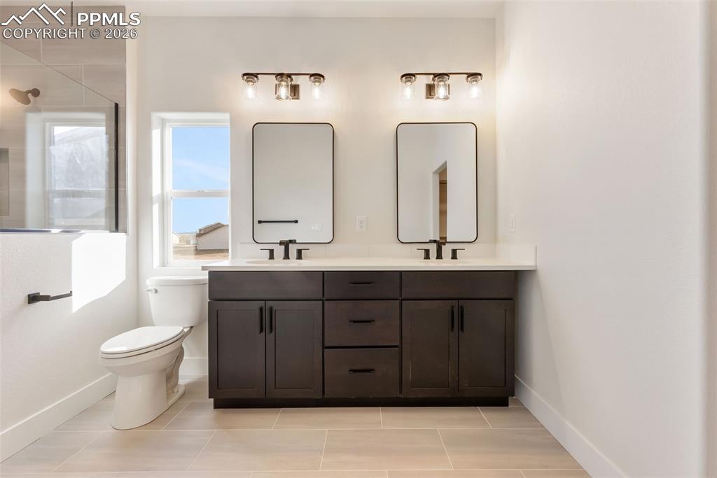 806 Keystone Loop Canon City, CO 81212 - Photo 12 of 39 a bathroom with double vanity sinks a toilet a mirror and vanity