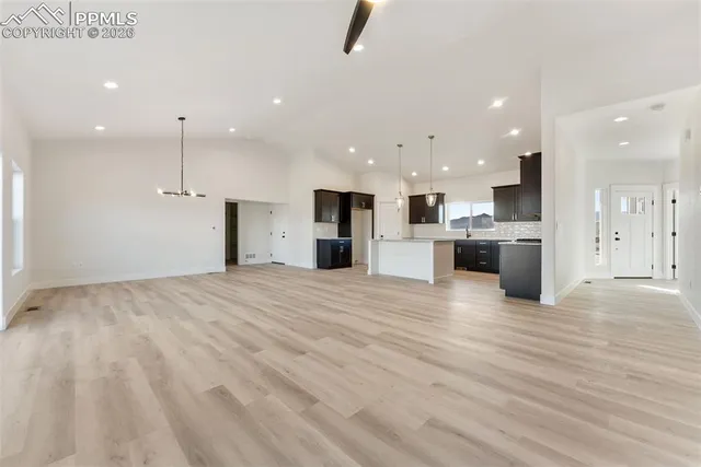 an empty room with kitchen view and a window