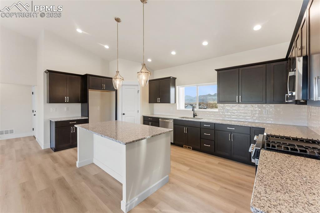 806 Keystone Loop Canon City, CO 81212 - Photo 4 of 39 a large kitchen with stainless steel appliances kitchen island granite countertop a refrigerator a stove a sink and a oven with wooden floor
