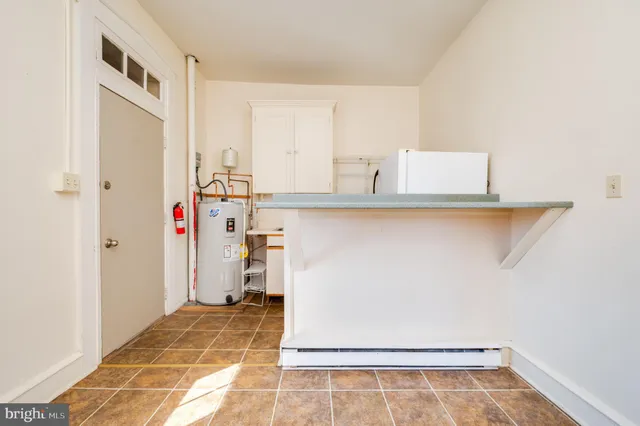 a view of a kitchen with white cabinets and wooden floor