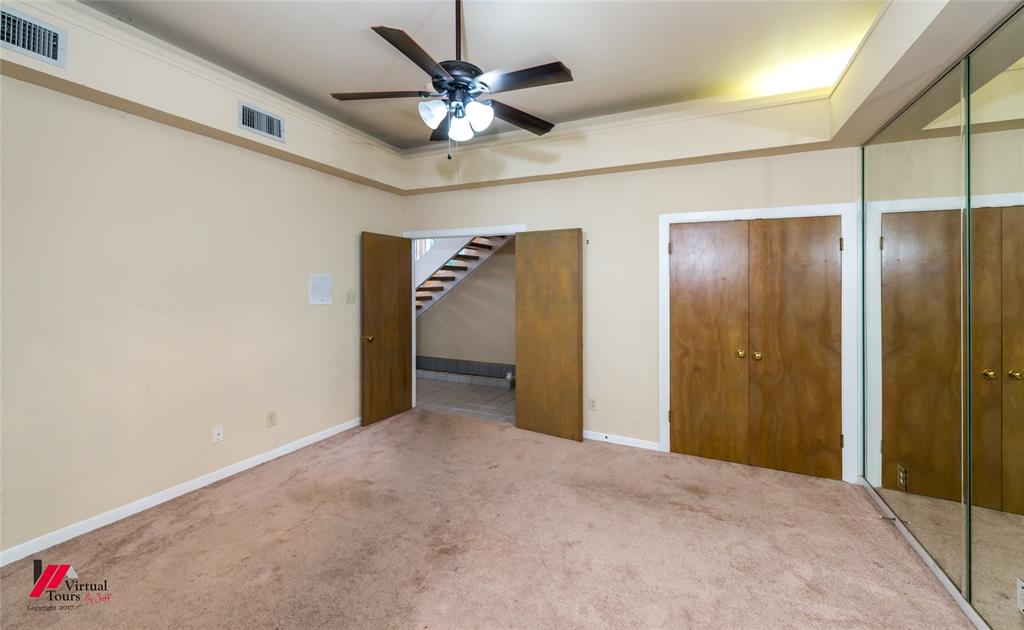 300 Pierremont Road, Unit 40 Shreveport, LA 71106 - Photo 9 of 34 Carpeted room featuring a ceiling fan with integrated lighting, wood-finish bi-fold closet doors, and a full-height mirrored wall