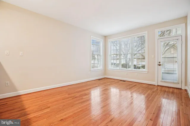 a view of empty room with wooden floor and fireplace
