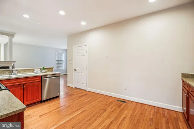 a view of empty room with wooden floor and ceiling fan