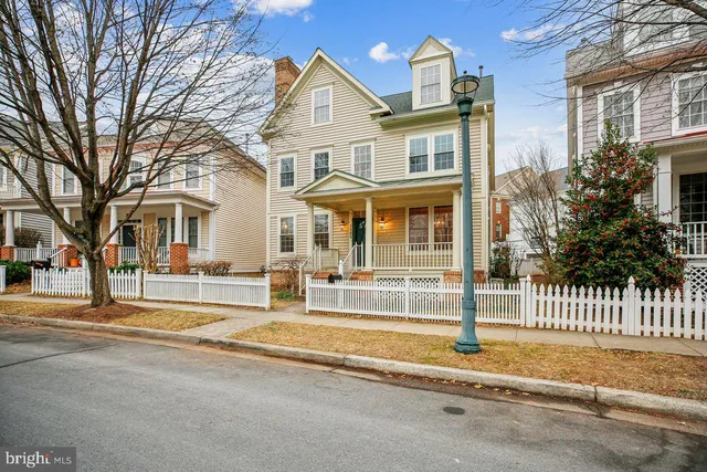 a view of an empty room with wooden floor fireplace and a window
