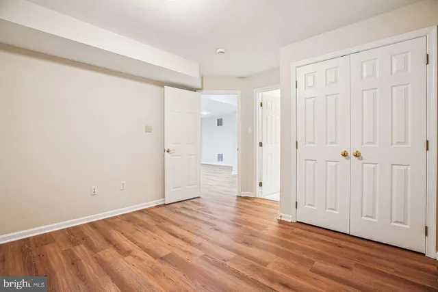 a room with wooden floor pool table and windows