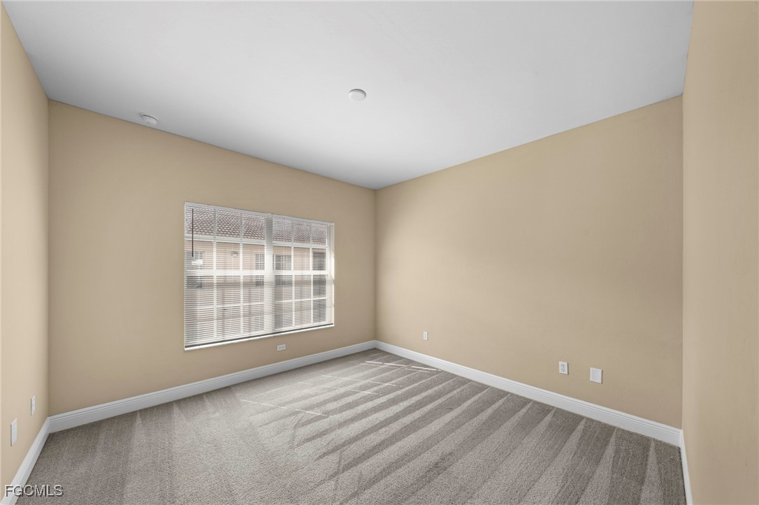 4172 Castilla Circle, Unit 102 Fort Myers, FL 33916 - Photo 10 of 37 an empty room with wooden floor and windows