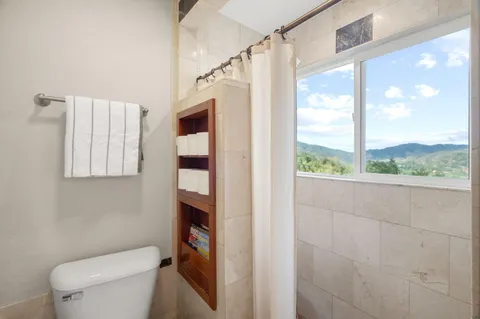 a bathroom with a toilet and a shower