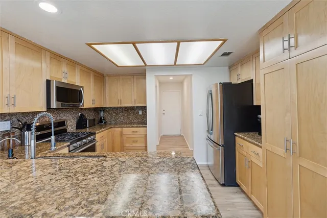 a kitchen with stainless steel appliances granite countertop a refrigerator oven a stove top oven a sink and dishwasher