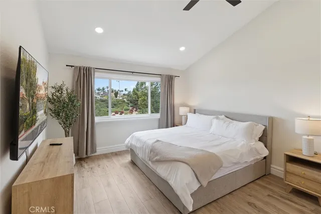 a bedroom with a large bed and a flat tv screen on dresser