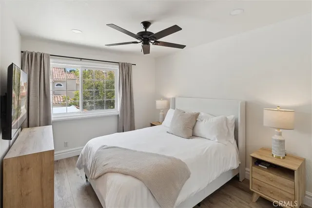 a bedroom with a bed and a flat tv screen on a dresser