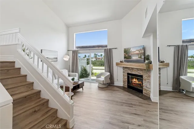 a living room with wooden floor and a fireplace