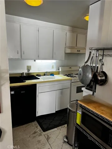 a white stove top oven sitting inside of a kitchen