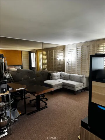 a living room with furniture a flat screen tv and a window