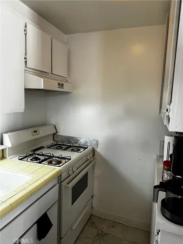 a white stove top oven sitting inside of a kitchen