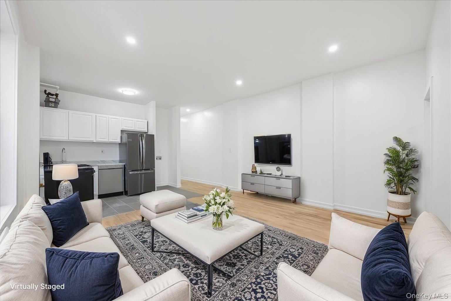 a living room with furniture kitchen view and a flat screen tv