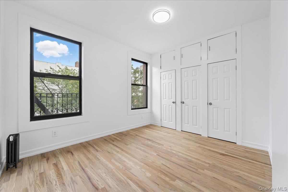 160 Wadsworth Avenue, Unit 302 Manhattan, NY 10033 - Photo 10 of 21 an empty room with wooden floor and windows