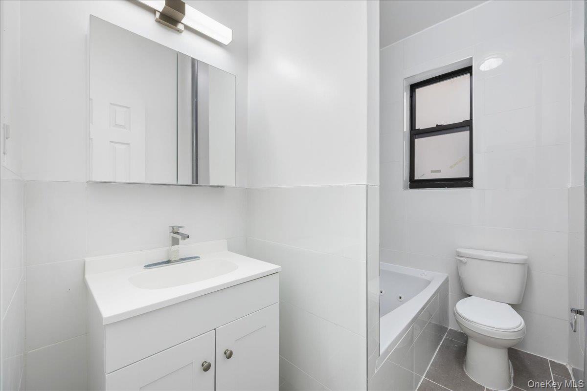 160 Wadsworth Avenue, Unit 302 Manhattan, NY 10033 - Photo 15 of 21 a bathroom with a toilet sink and mirror