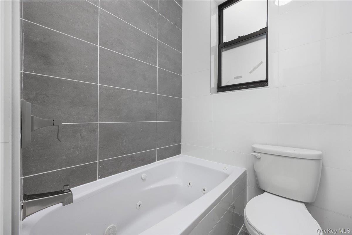 160 Wadsworth Avenue, Unit 302 Manhattan, NY 10033 - Photo 16 of 21 a white toilet sitting next to a bath tub