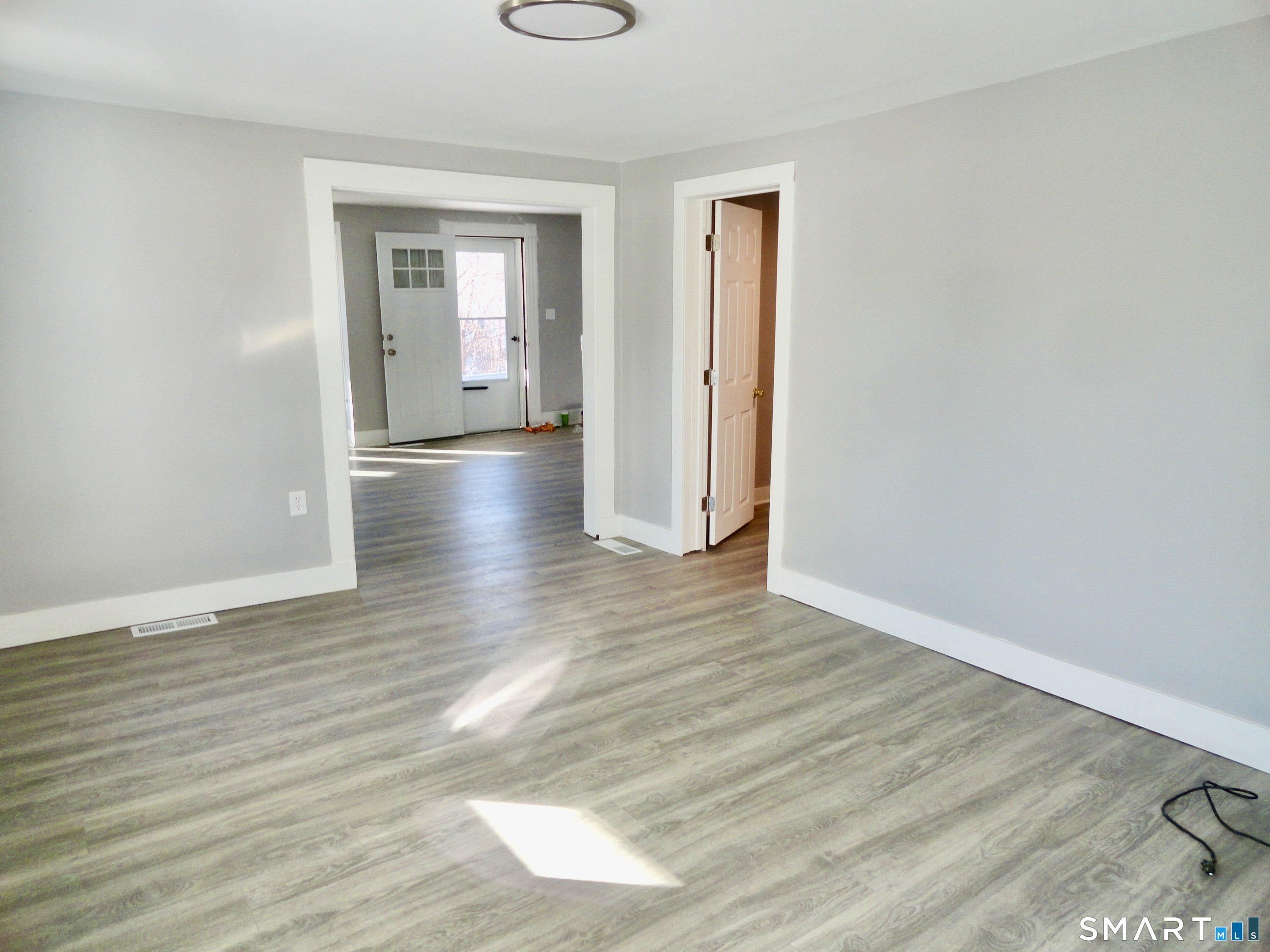 830 Main Street Winsted, CT 06098 - Photo 13 of 17 an empty room with wooden floor and windows