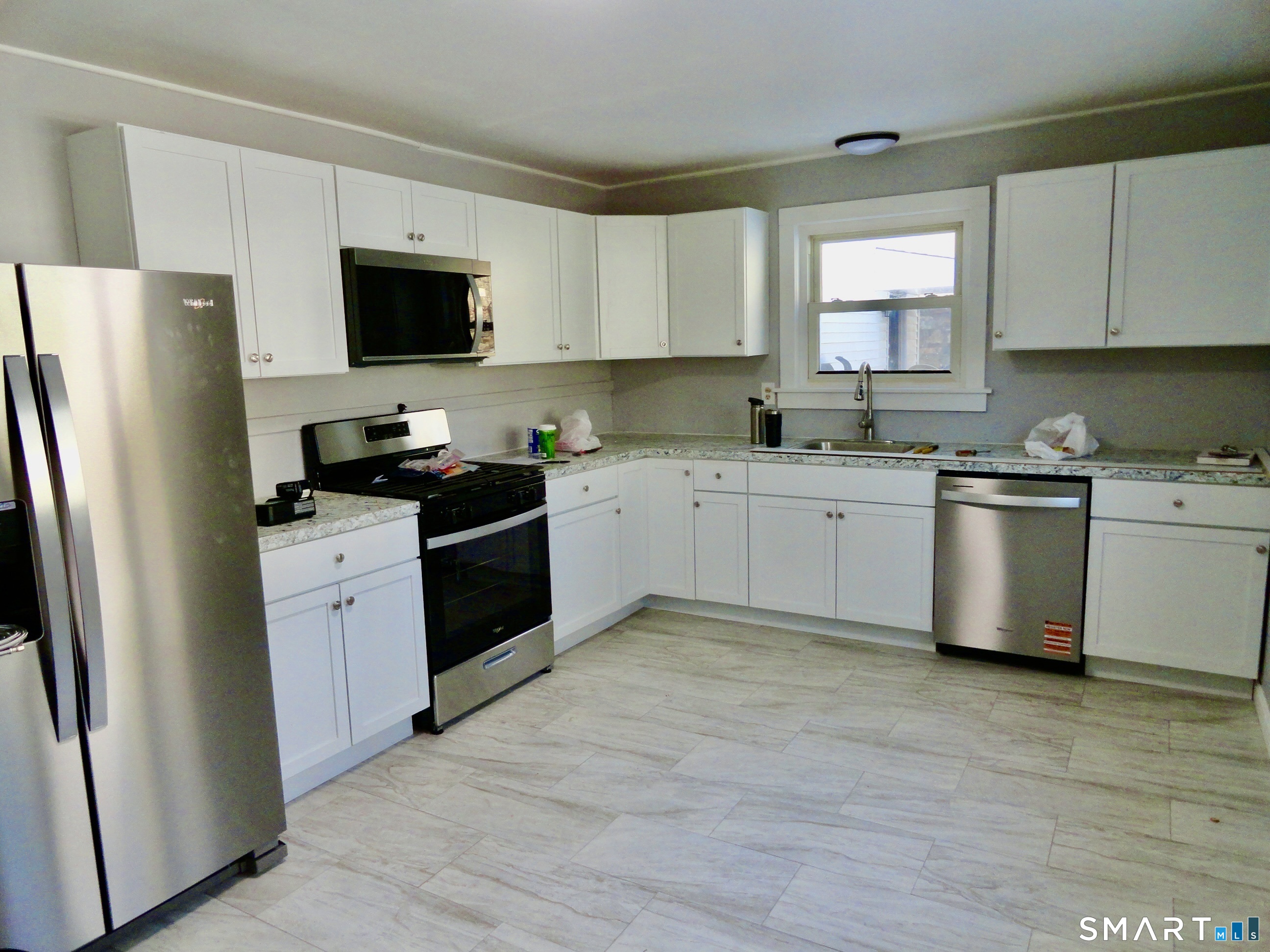 830 Main Street Winsted, CT 06098 - Photo 3 of 17 a kitchen with a sink white cabinets and stainless steel appliances