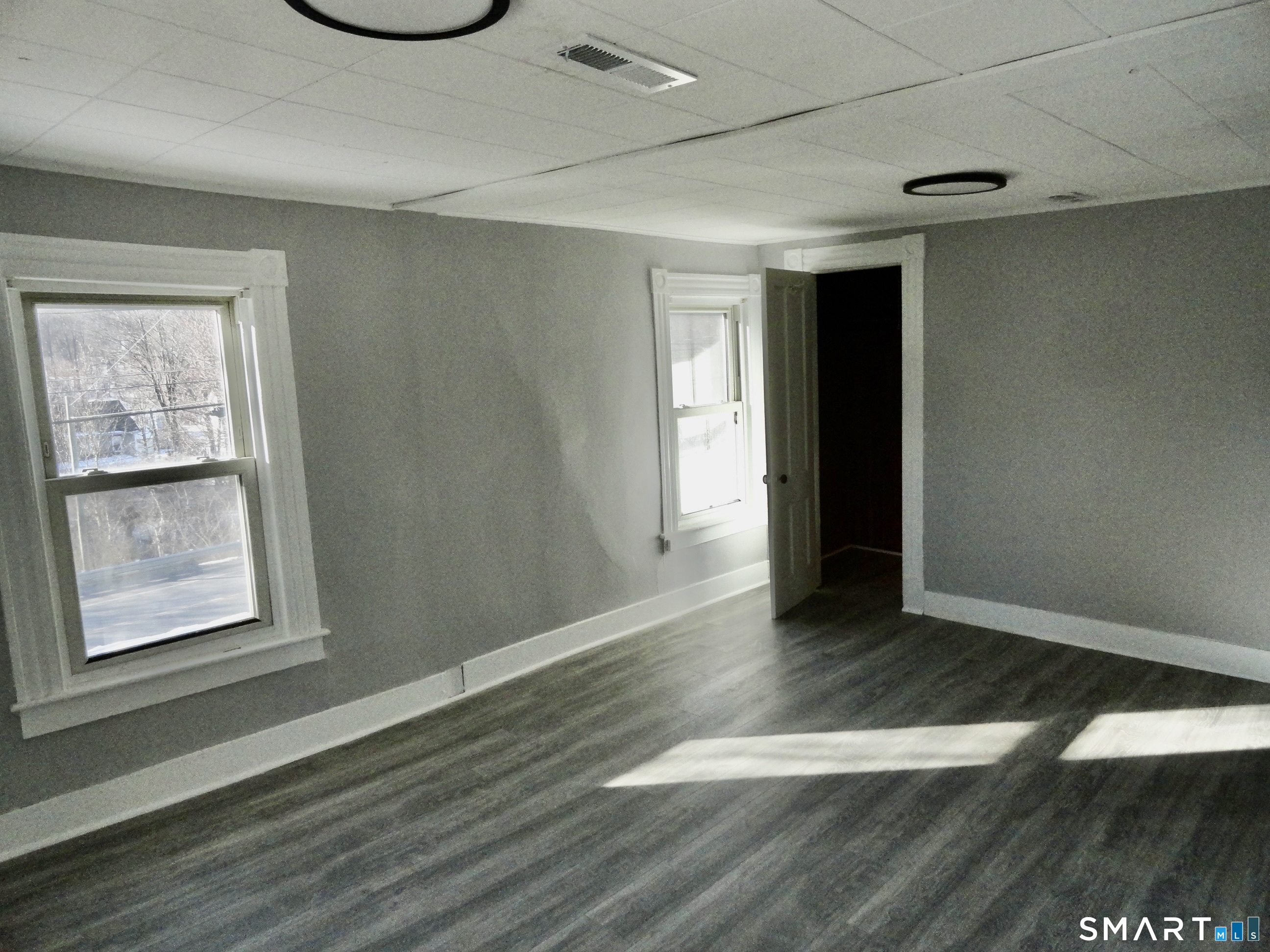 830 Main Street Winsted, CT 06098 - Photo 5 of 17 a view of an empty room with wooden floor and a window