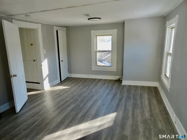 an empty room with wooden floor and a window